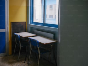 una habitación con una mesa y dos sillas junto a una ventana
