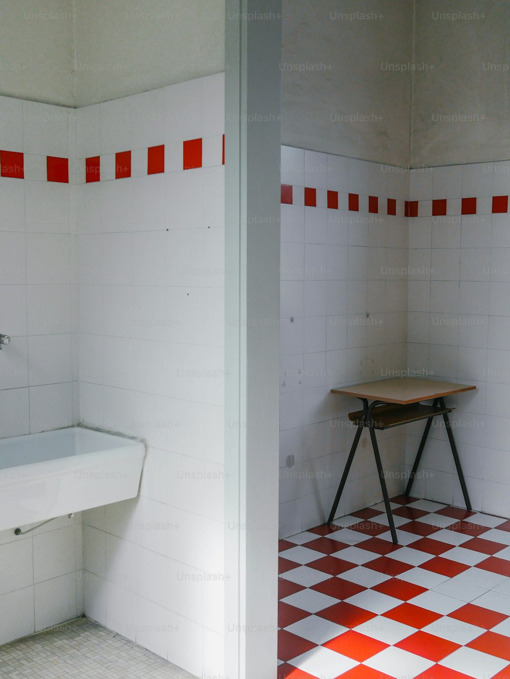 uma casa de banho com piso quadriculado vermelho e branco