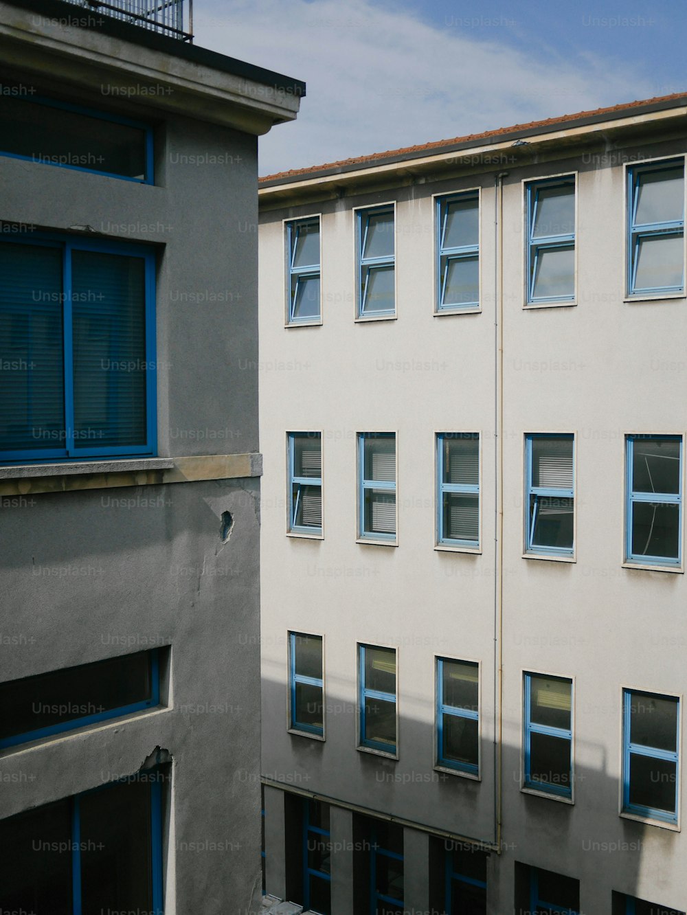 um edifício alto com janelas azuis ao lado de outro edifício