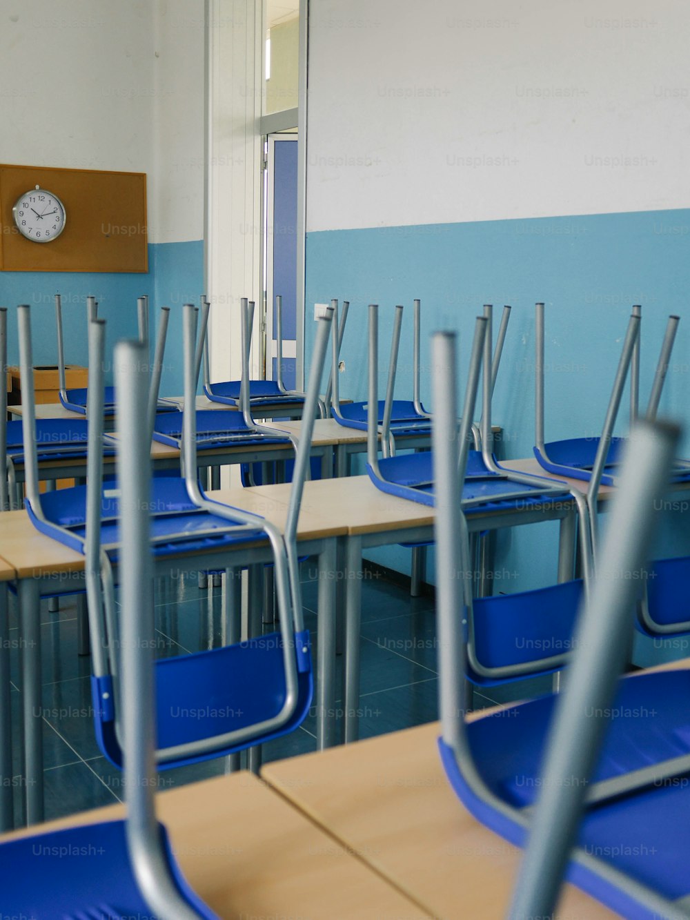 a classroom with blue chairs and a clock on the wall