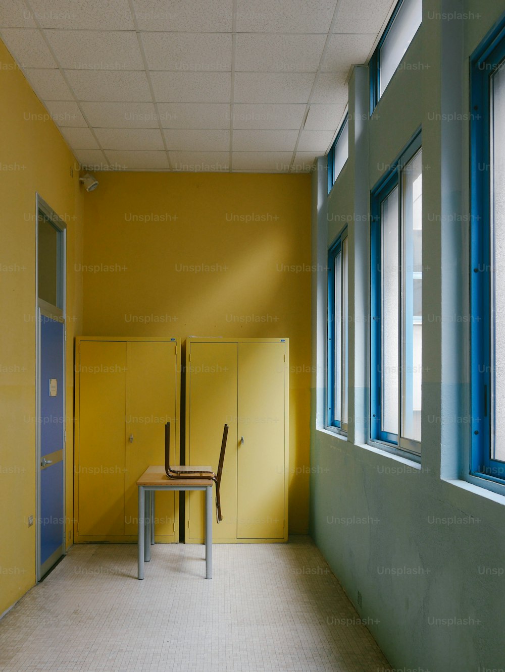 a chair sitting in a room next to a yellow wall
