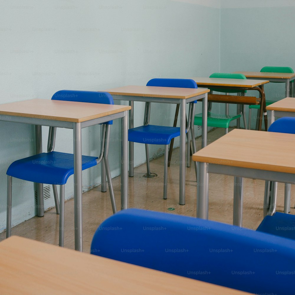 a row of desks in a classroom with blue chairs