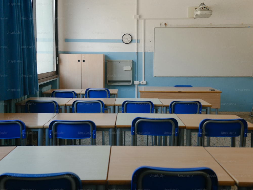 ein Klassenzimmer mit blauen Stühlen und einem Whiteboard
