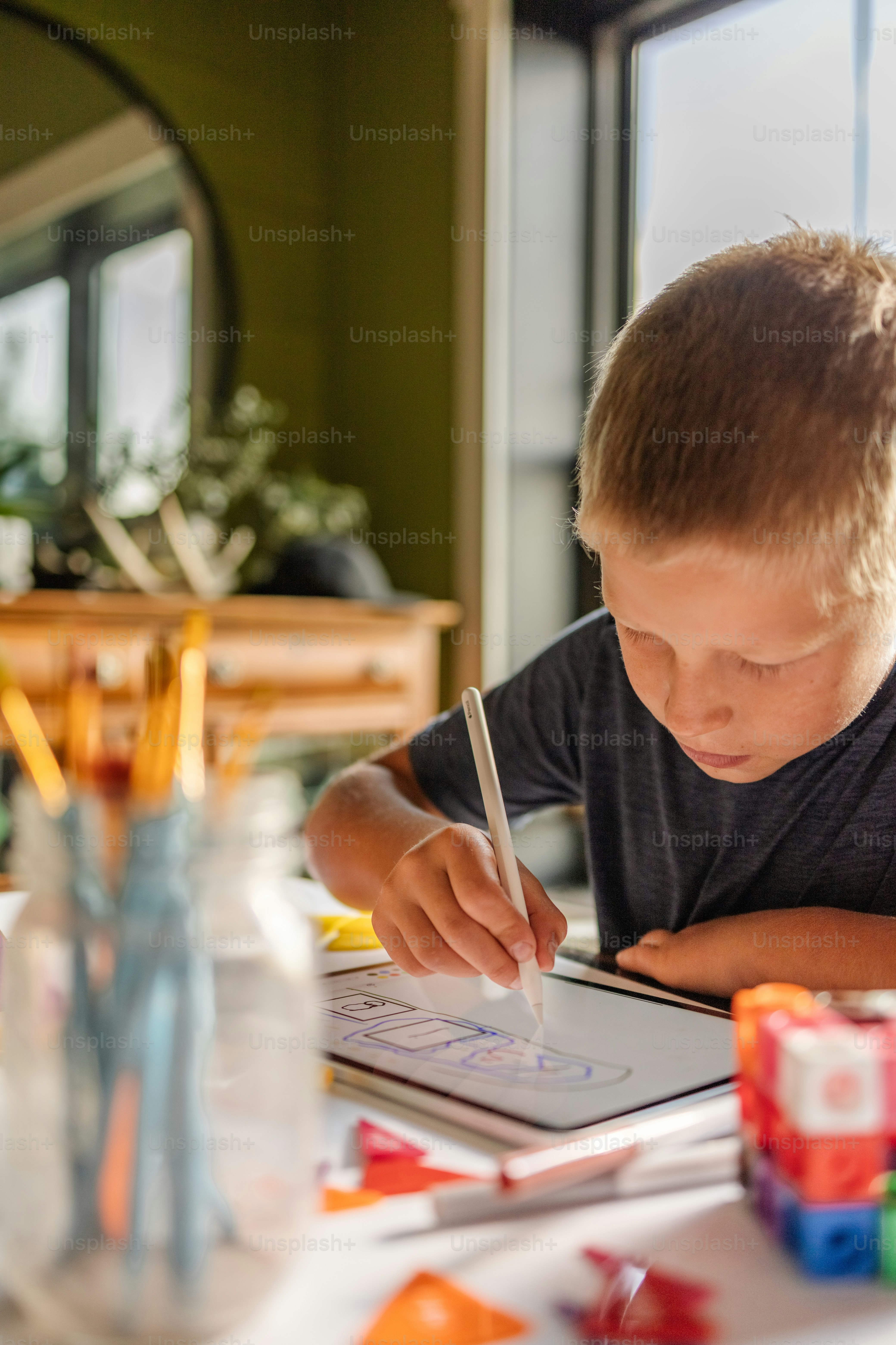 Un jeune garçon assis à une table écrivant sur un morceau de papier