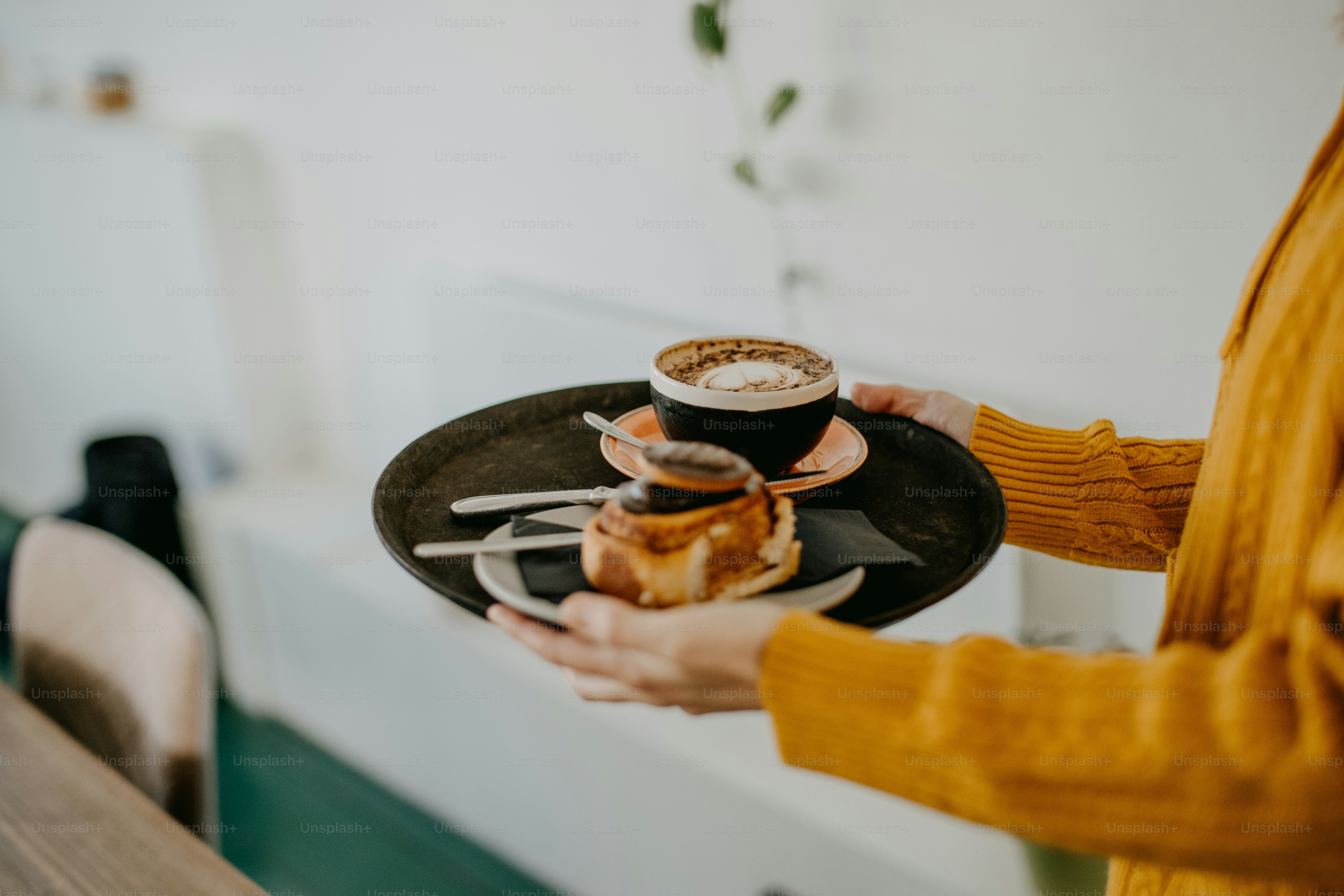 Una mujer sosteniendo un plato de comida y una taza de café