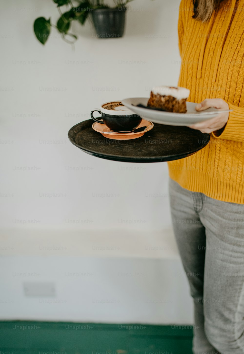 a woman holding a plate with a piece of cake on it