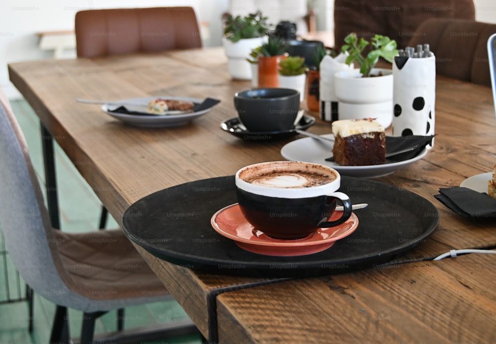 ein Holztisch mit einem Teller mit Essen und einer Tasse Kaffee
