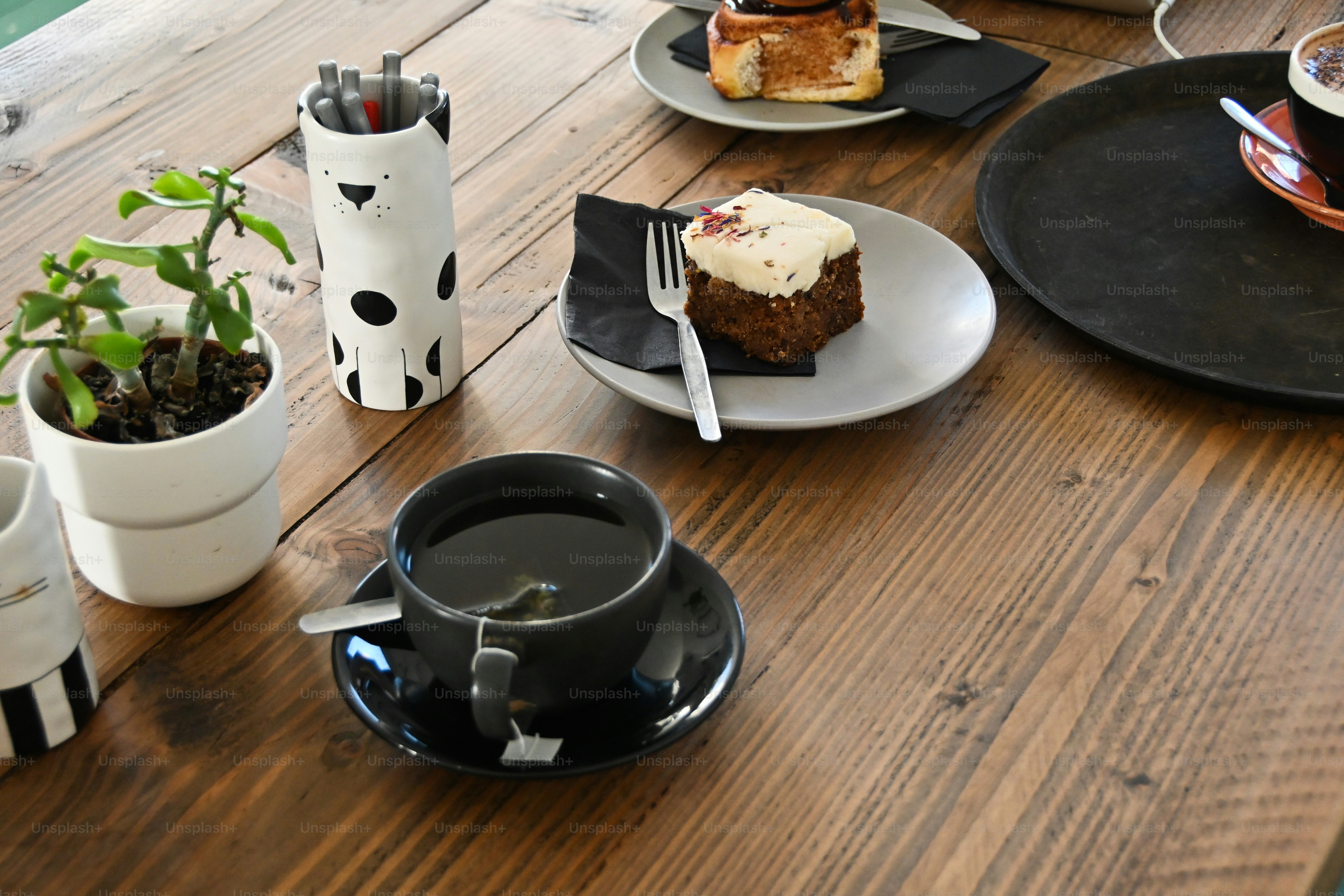 a wooden table topped with plates of food and cups of coffee