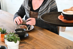 Una mujer sentada en una mesa con un plato de comida