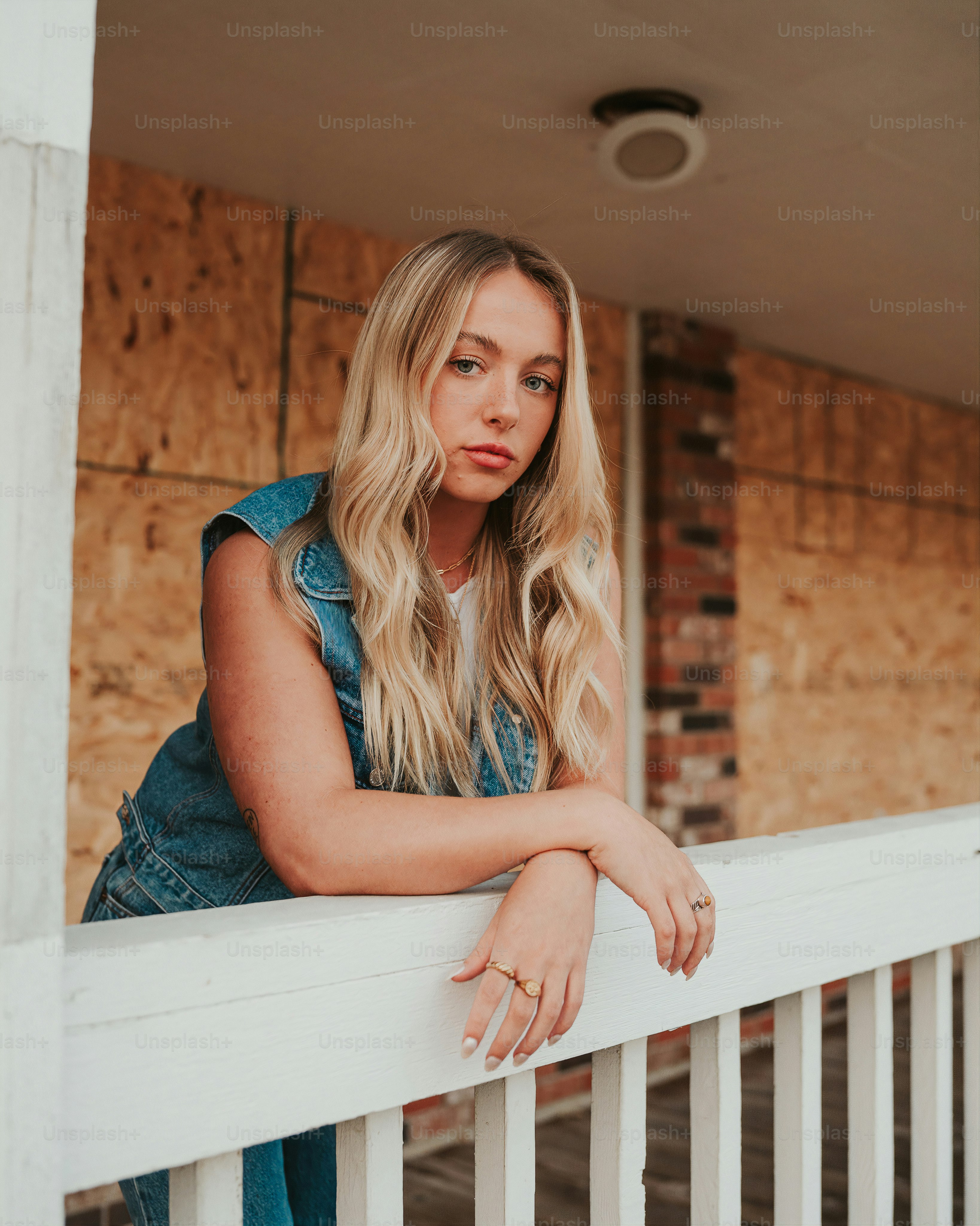 uma mulher apoiada em um corrimão de varanda