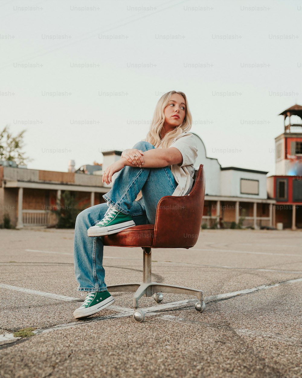 a woman sitting on a chair in a parking lot