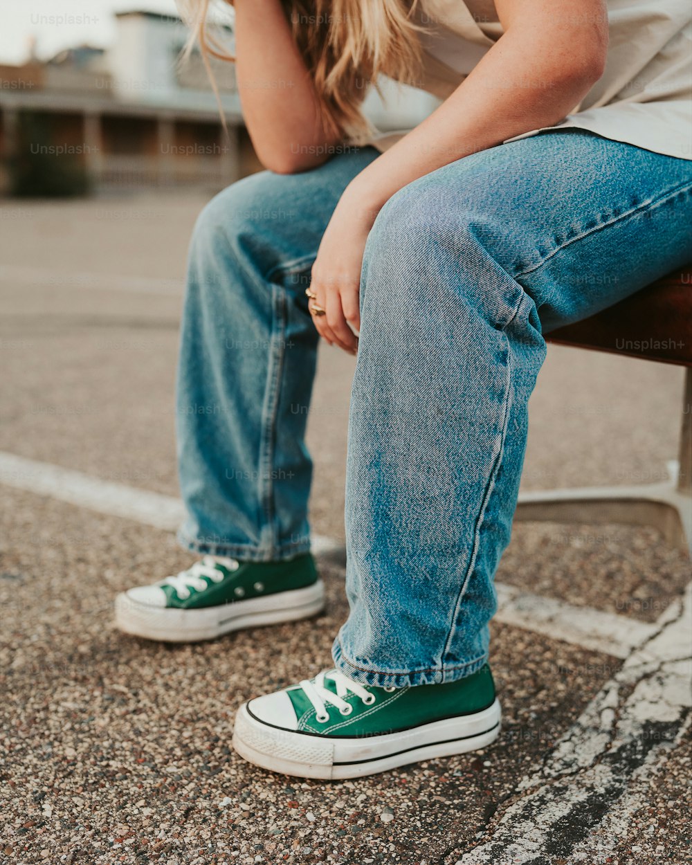 a person sitting on a bench with their legs crossed