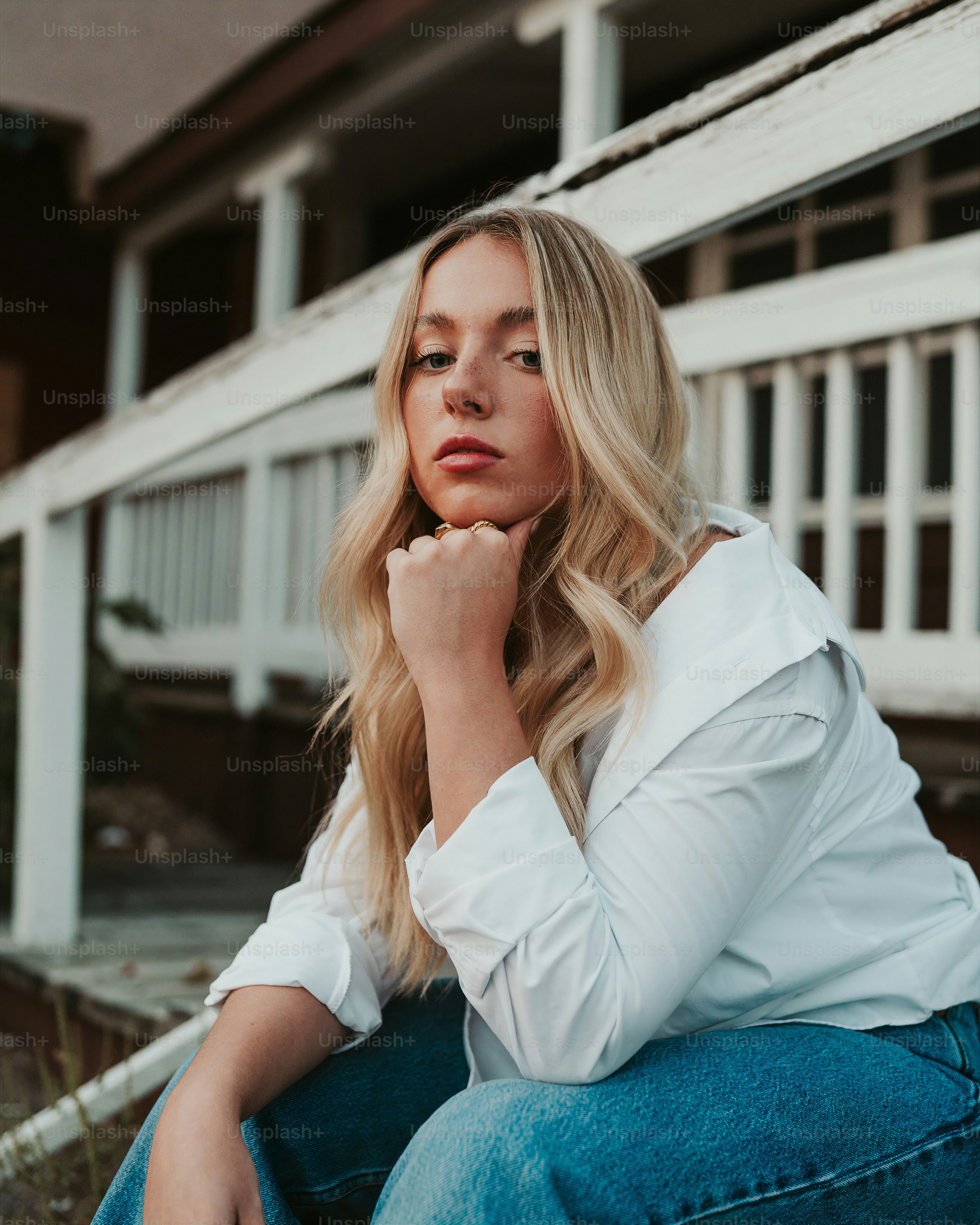 uma mulher sentada no chão com a mão no queixo