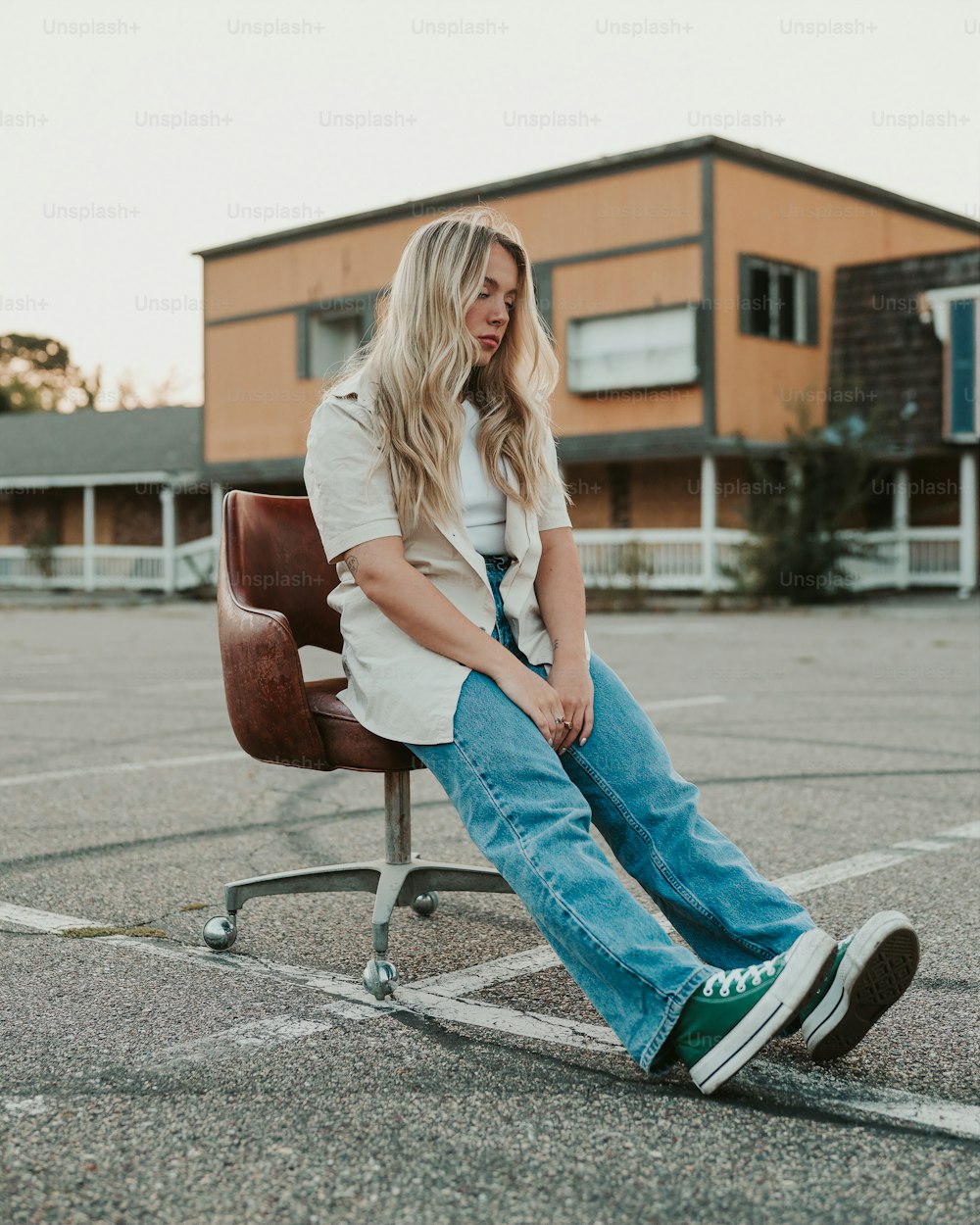 Long Legs Fashion Blonde Girl Sitting on Bench. Street Fashion. Stock Photo