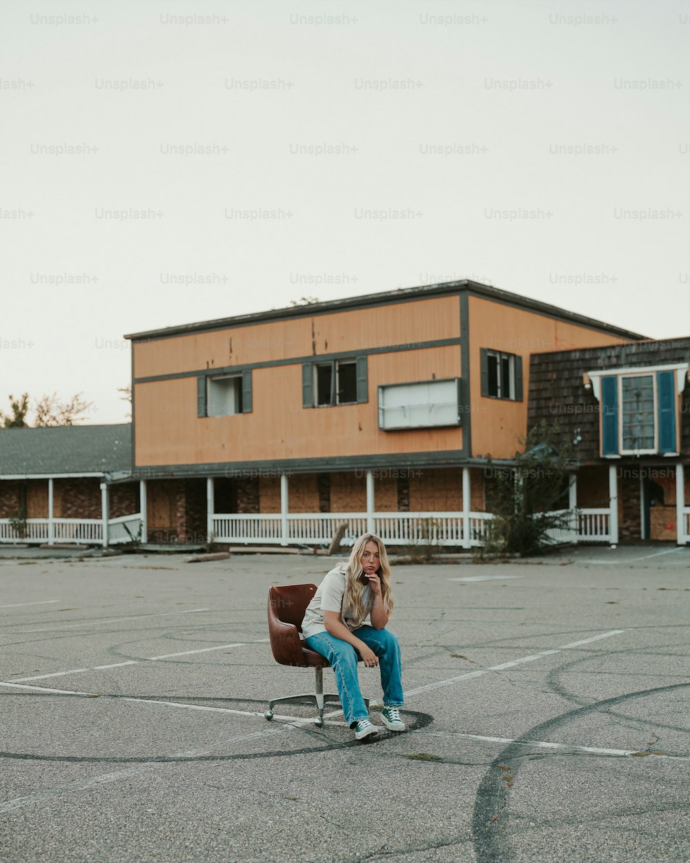駐車場の椅子に座っている女性