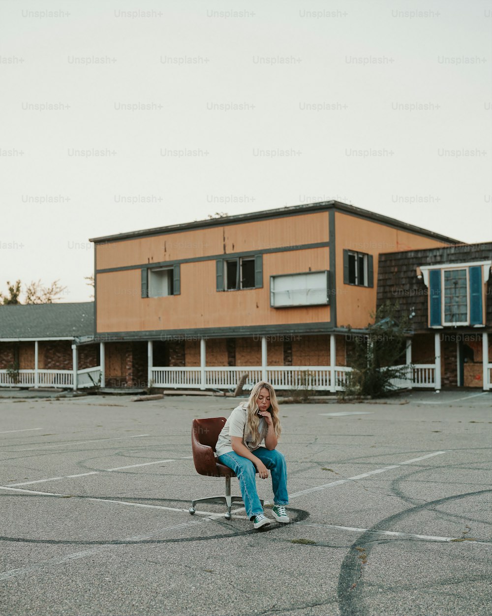 a woman sitting in a chair in a parking lot