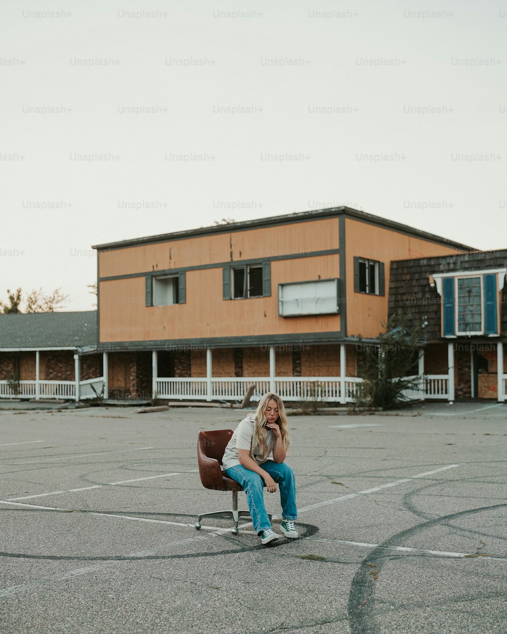 una donna che si siede su una sedia in un parcheggio