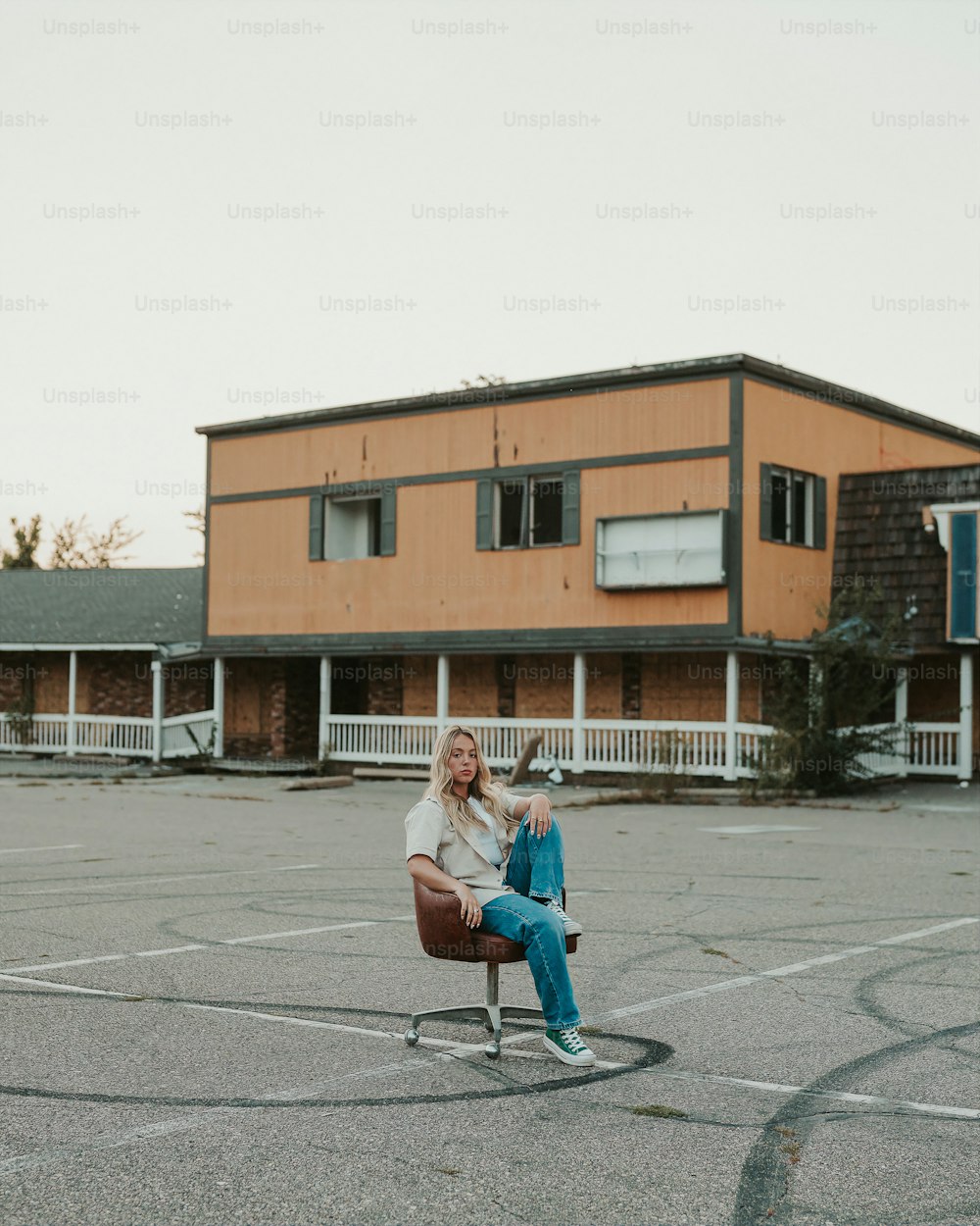 a woman sitting in a chair in a parking lot