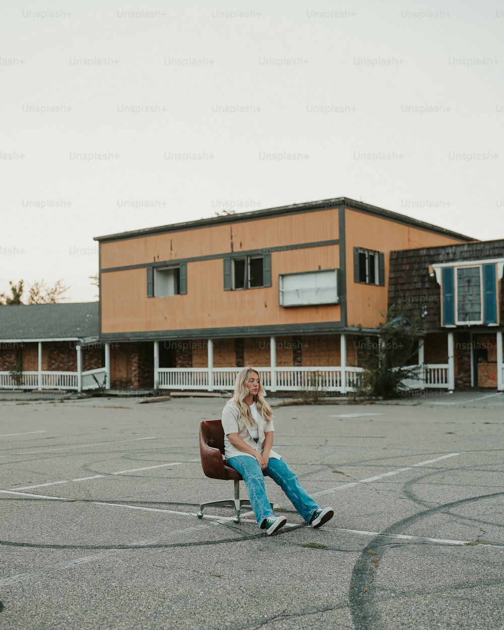 a woman sitting in a chair in a parking lot