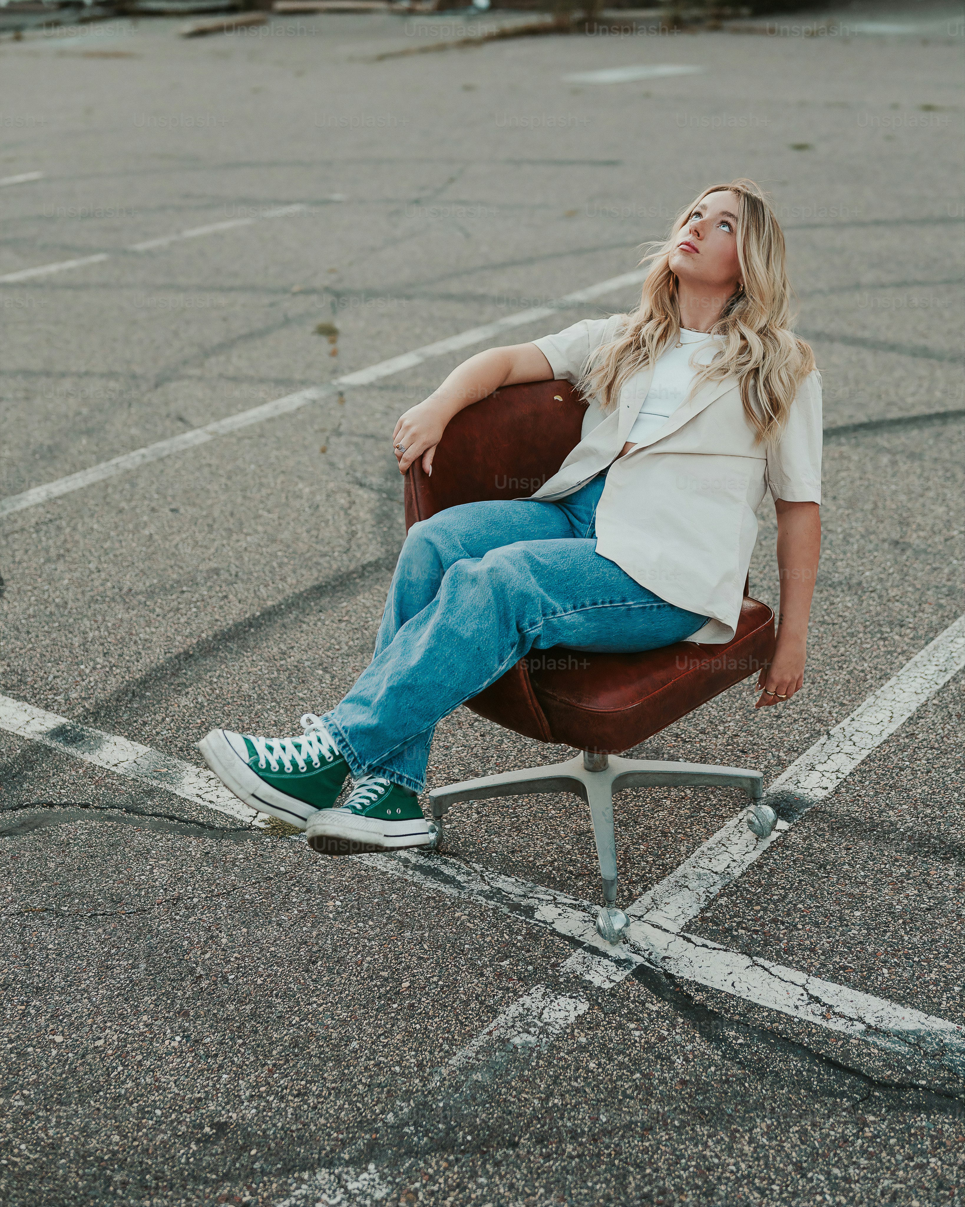 uma mulher sentada em uma cadeira em um estacionamento