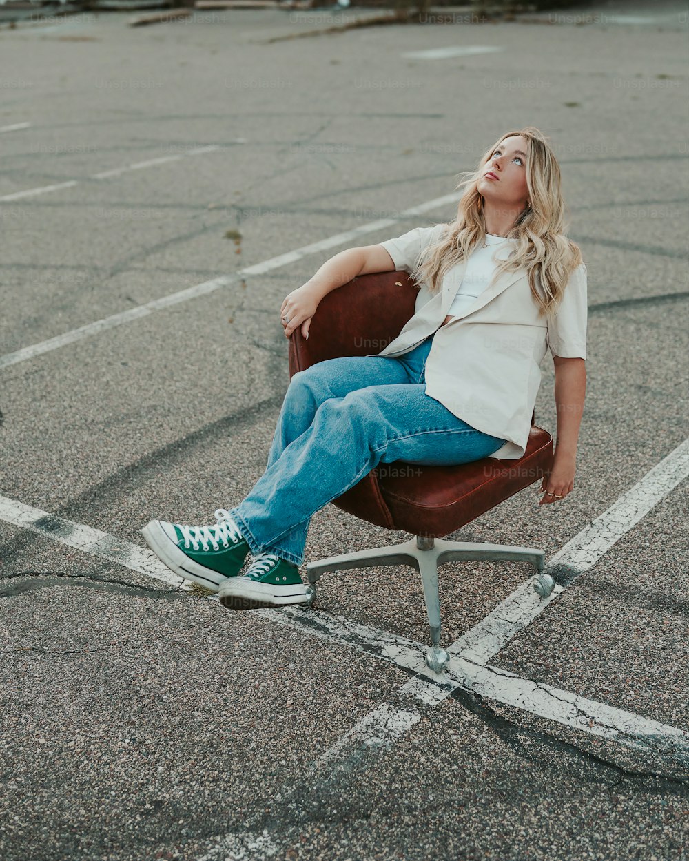 uma mulher sentada em uma cadeira em um estacionamento