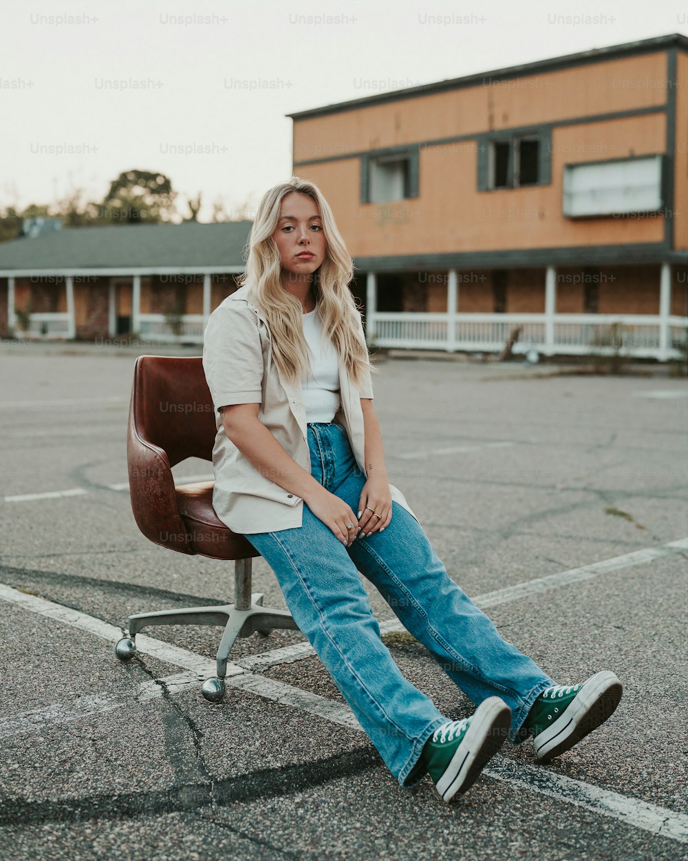 a woman sitting on a chair in a parking lot