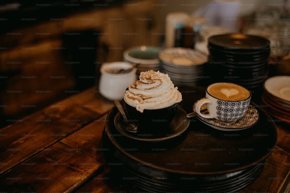 duas xícaras de café sentadas em cima de uma mesa de madeira