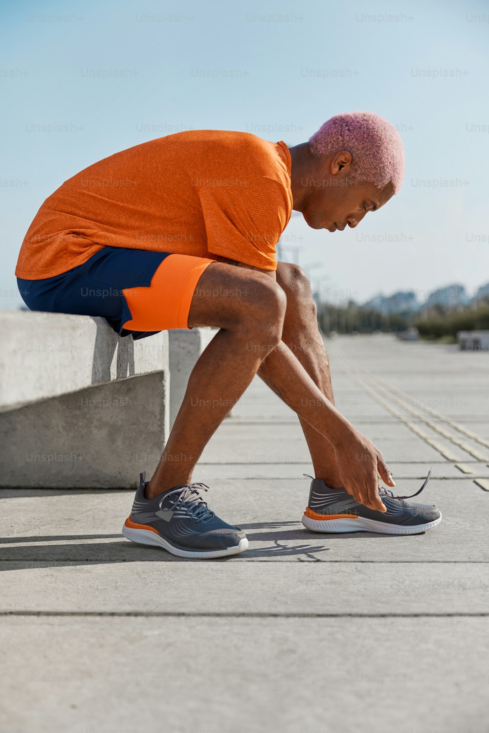 a man sitting on a bench with his foot on the ground