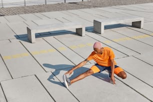a man sitting on the ground with a skateboard