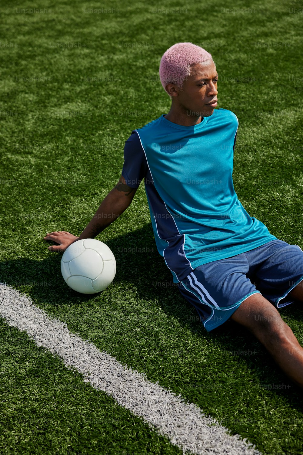 a man sitting on the ground with a soccer ball