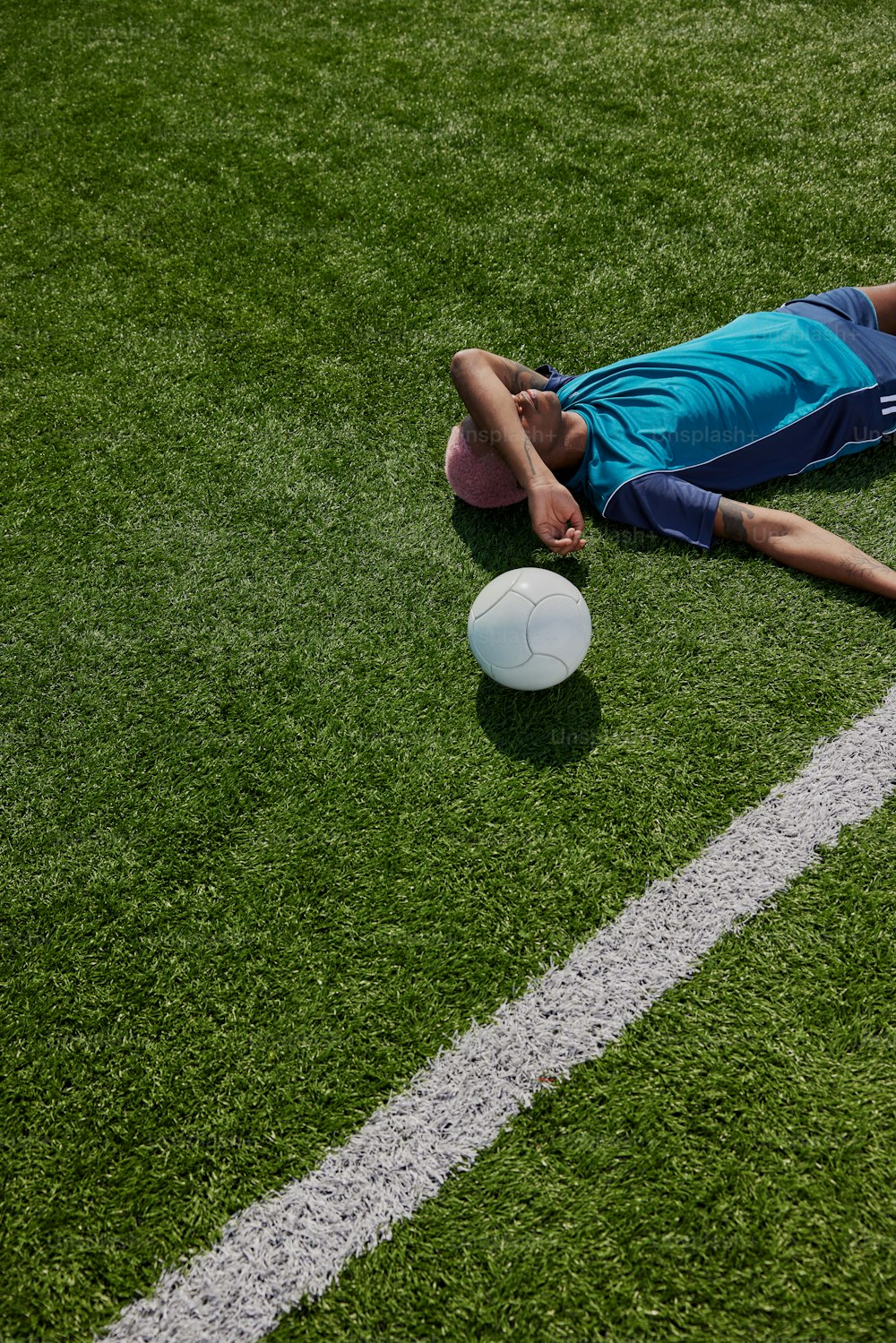 a man laying on the ground next to a white frisbee
