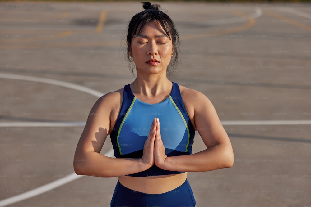 Una mujer con un sujetador deportivo azul está haciendo yoga
