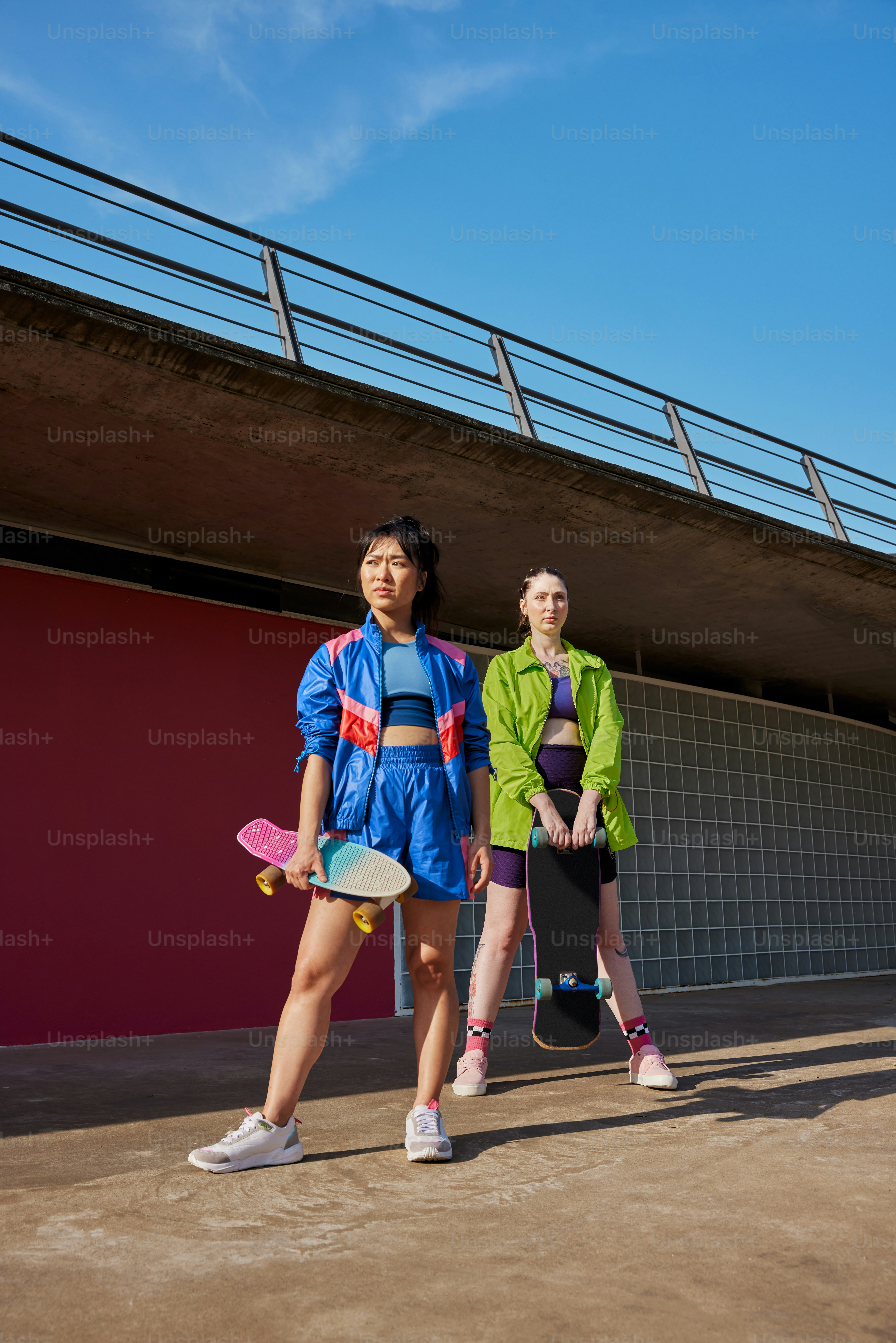 スケートボードを持って隣同士に立っている2人の女性