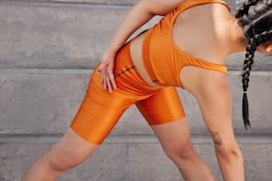 a woman in an orange sports bra and shorts