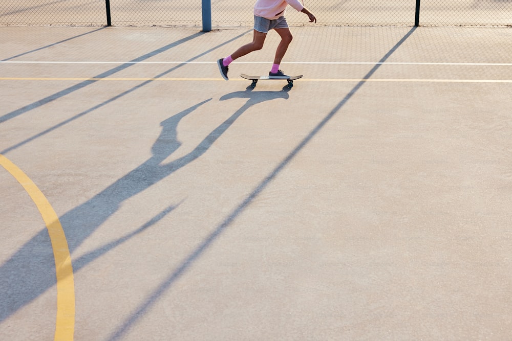 uma pessoa andando de skate em uma quadra de tênis