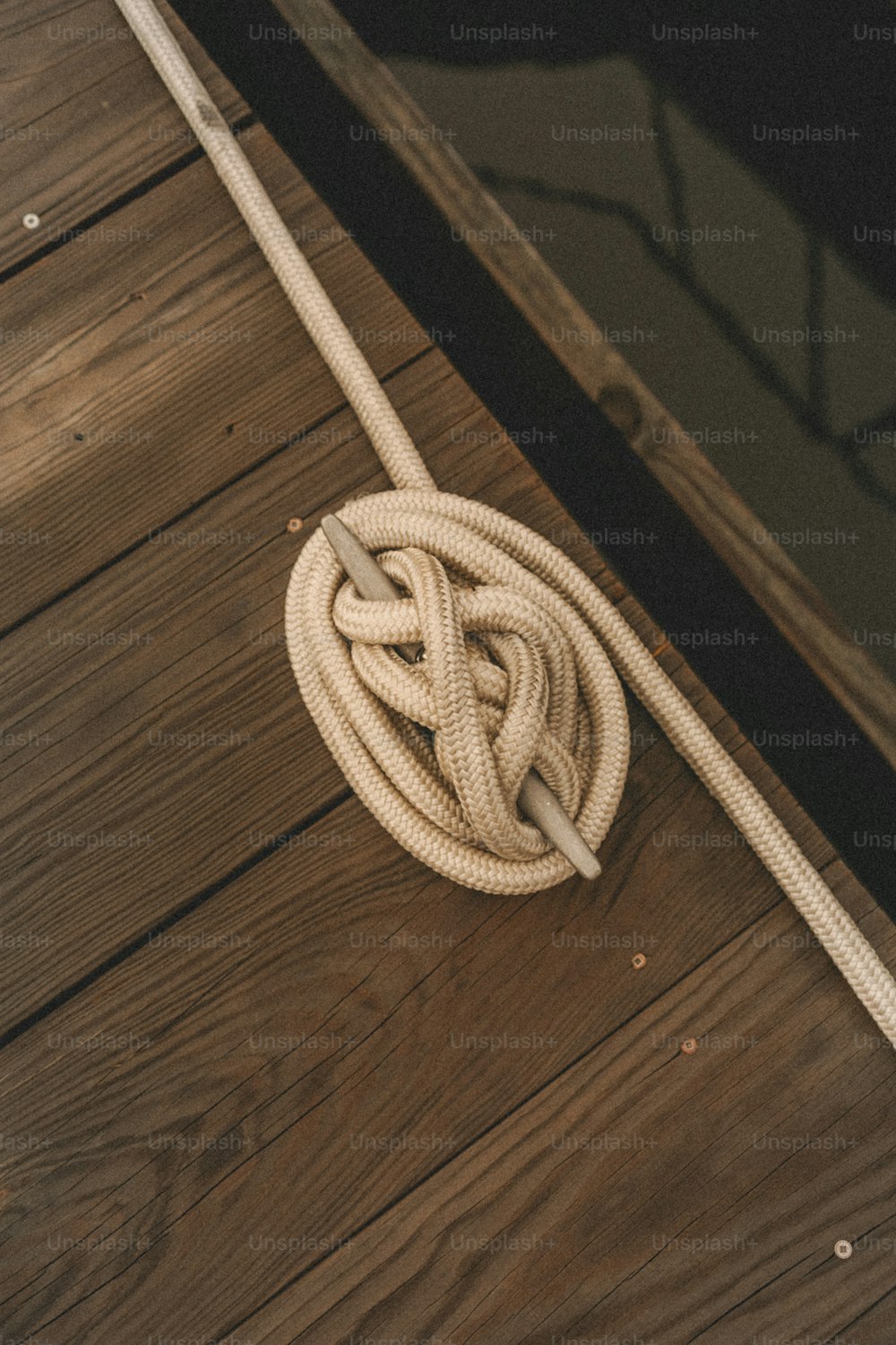 uma corda em um chão de madeira com um espelho no fundo
