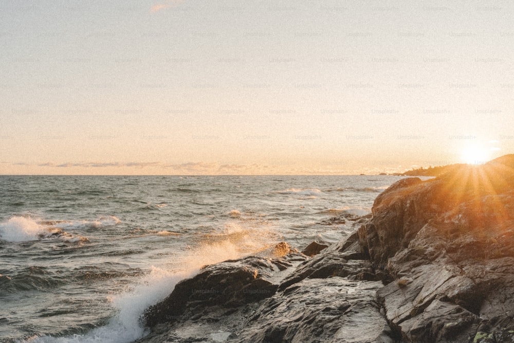 a person standing on a rock near the ocean