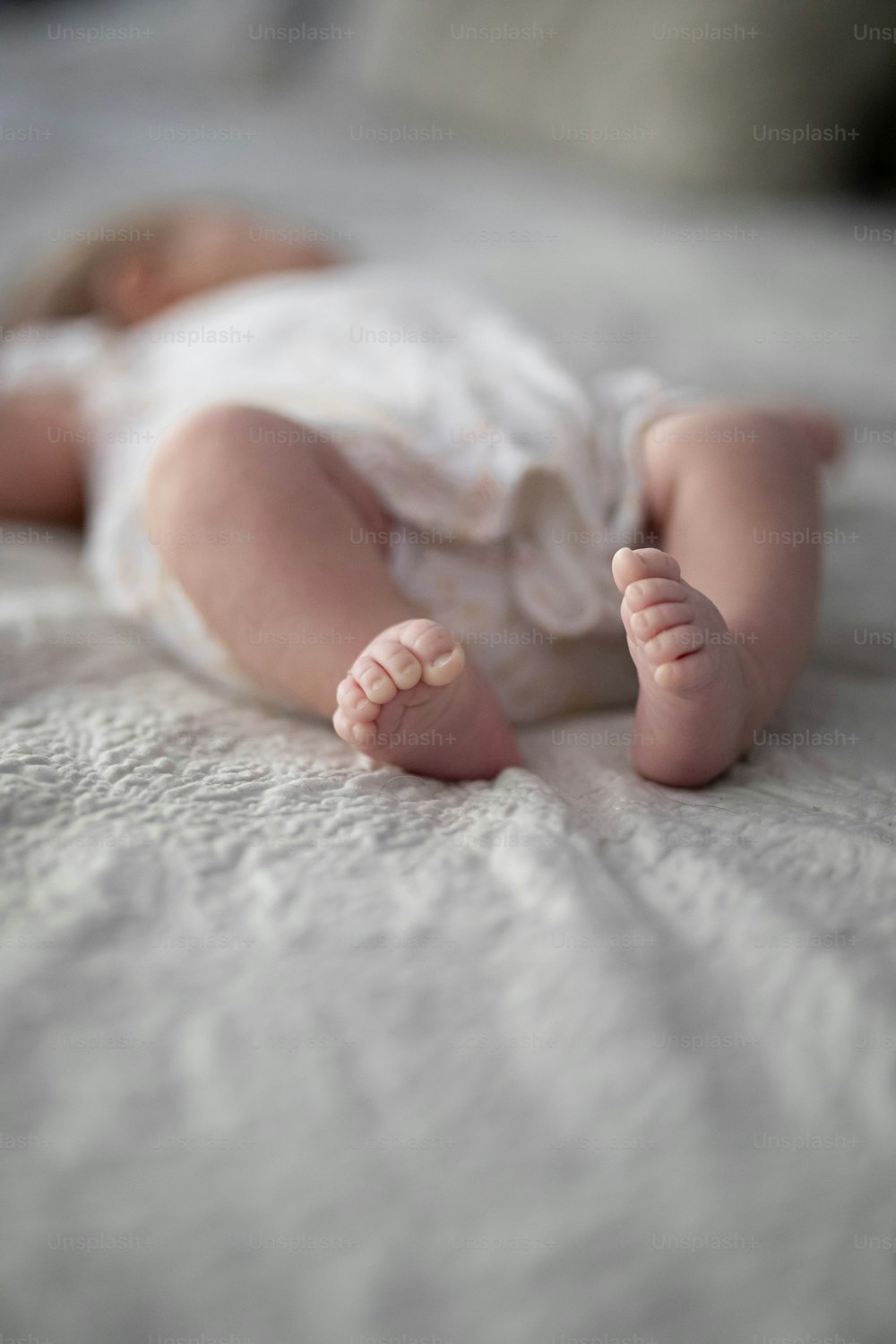 a baby laying on its back on a bed