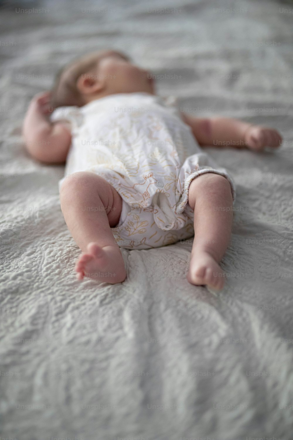 un bebé acostado boca arriba en una cama