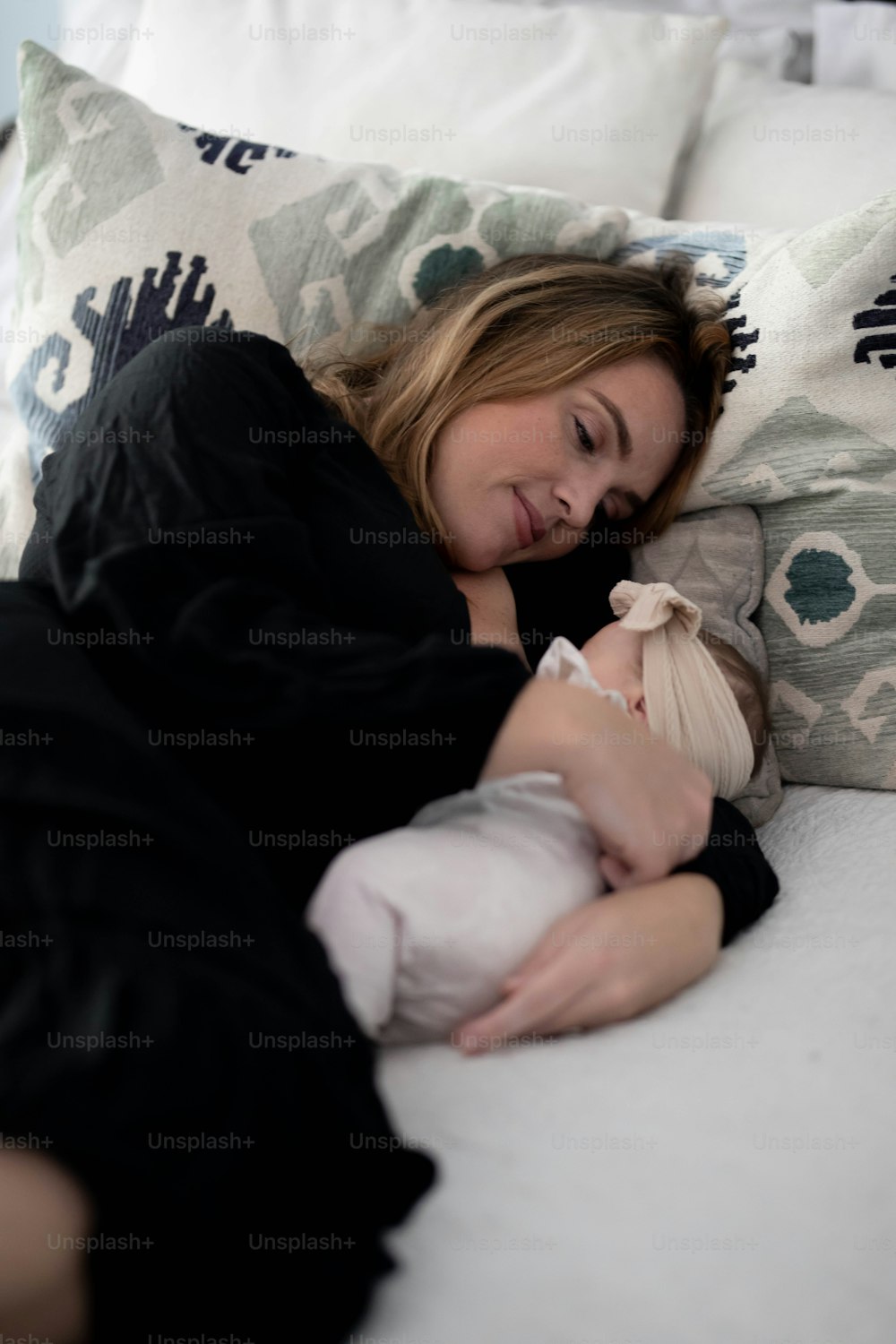 Eine Frau, die auf einem Bett liegt und ein Baby hält