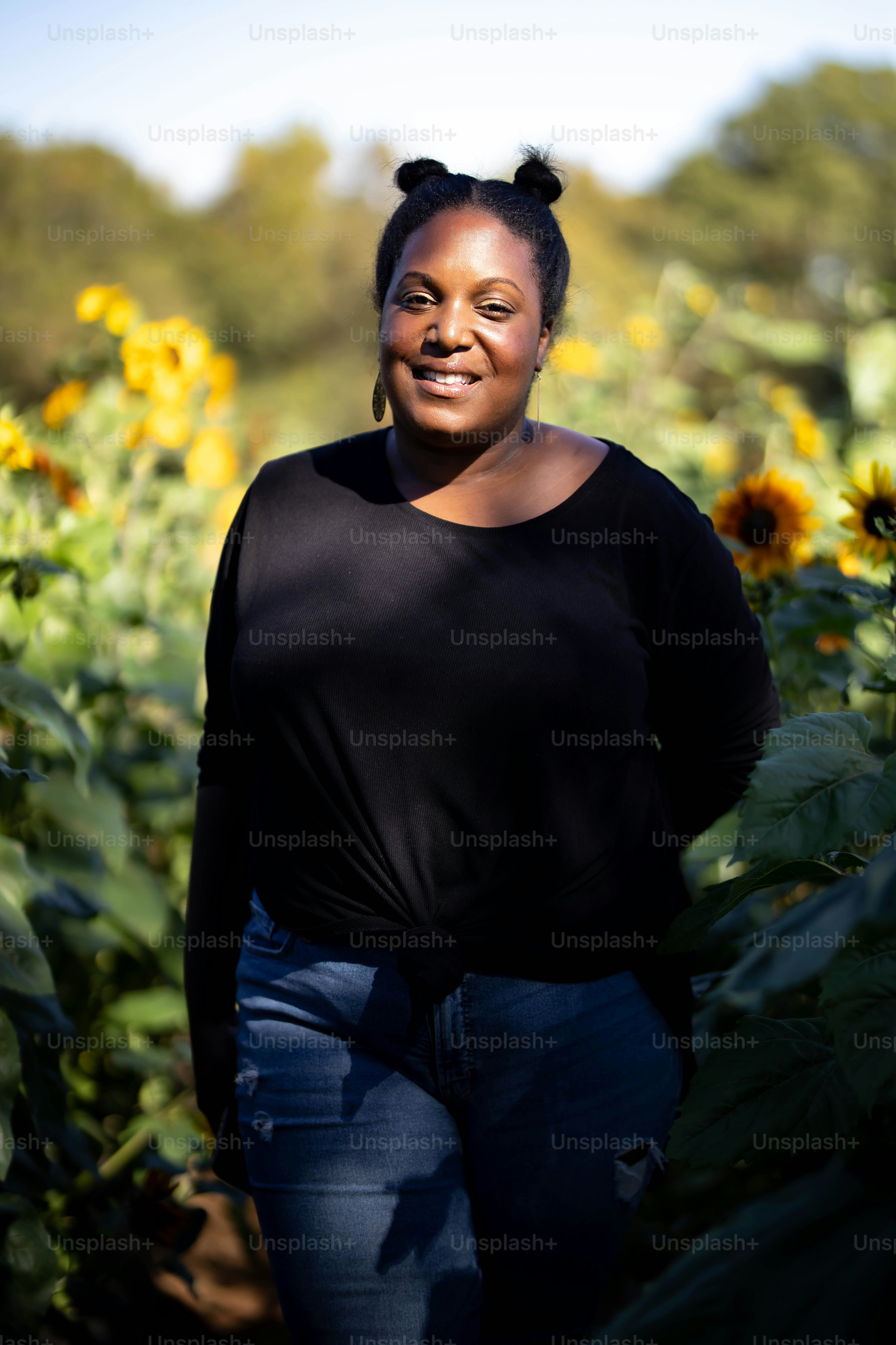 A woman standing in a field of sunflowers photo – Woman Image on Unsplash