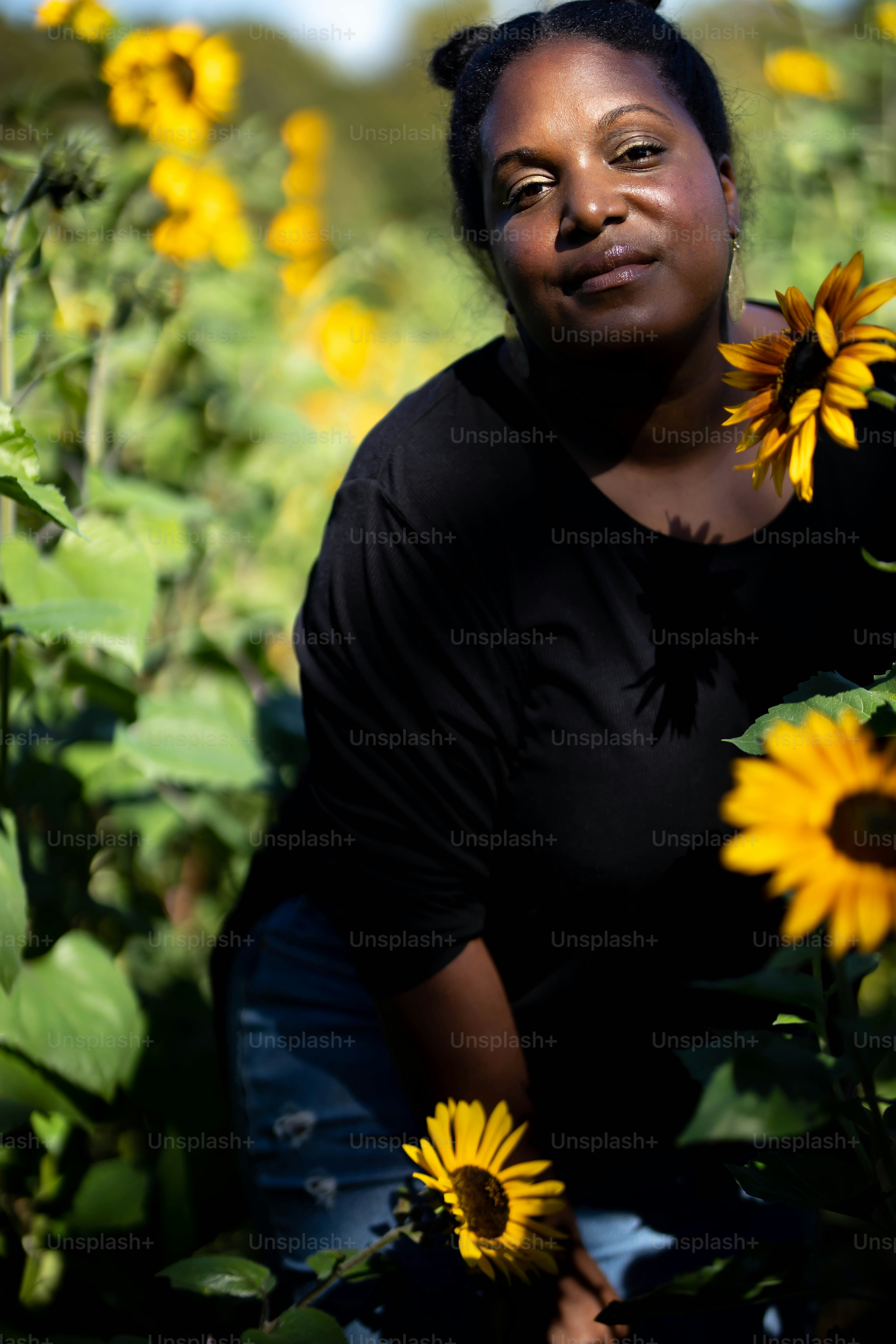 A woman standing in a field of sunflowers photo – Woman Image on Unsplash