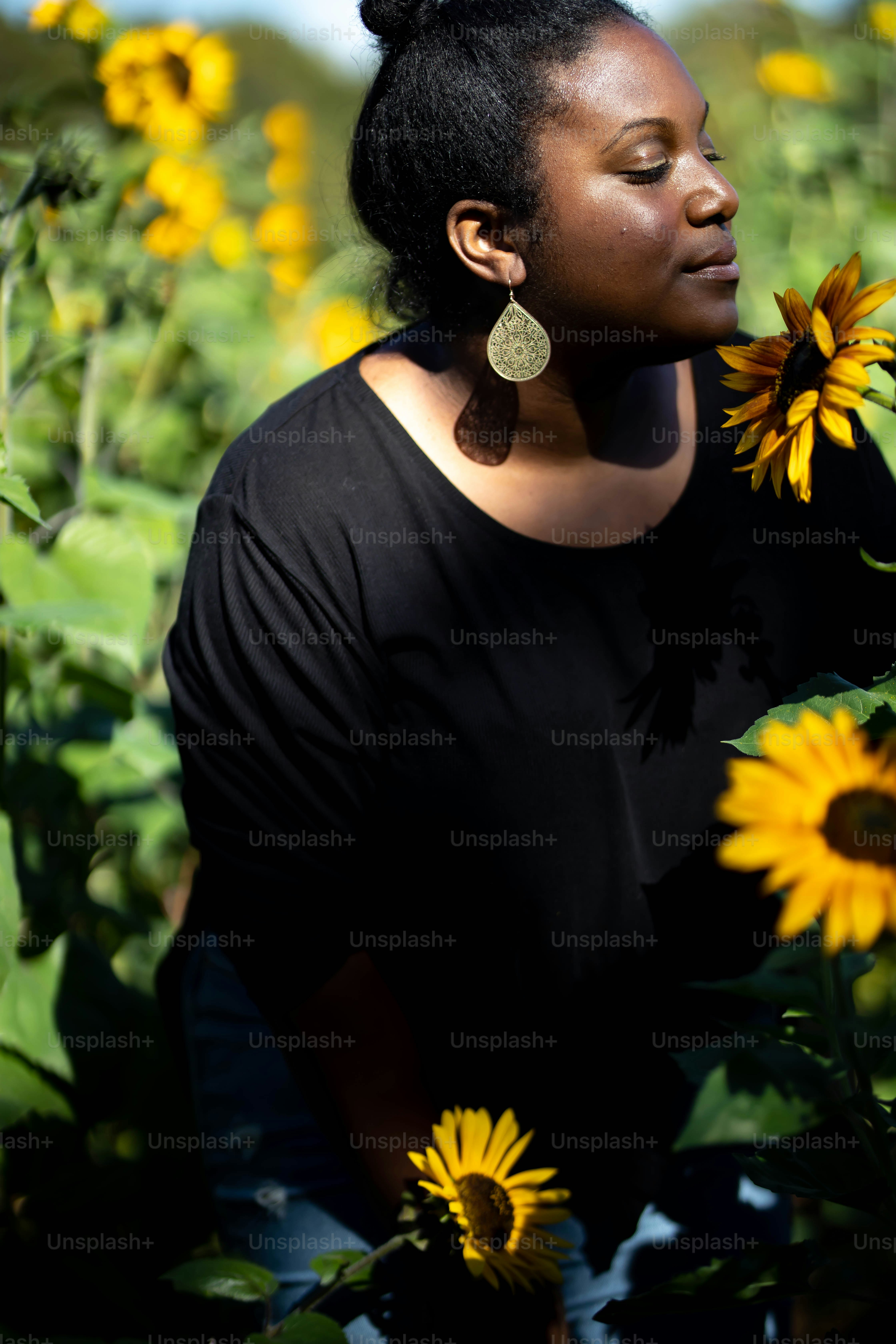 A woman standing in front of a field of sunflowers photo – Woman Image ...