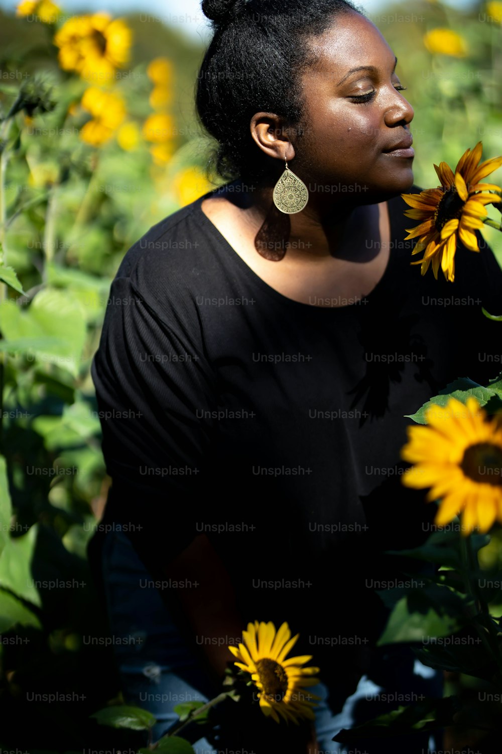 Eine Frau, die in einem Sonnenblumenfeld steht