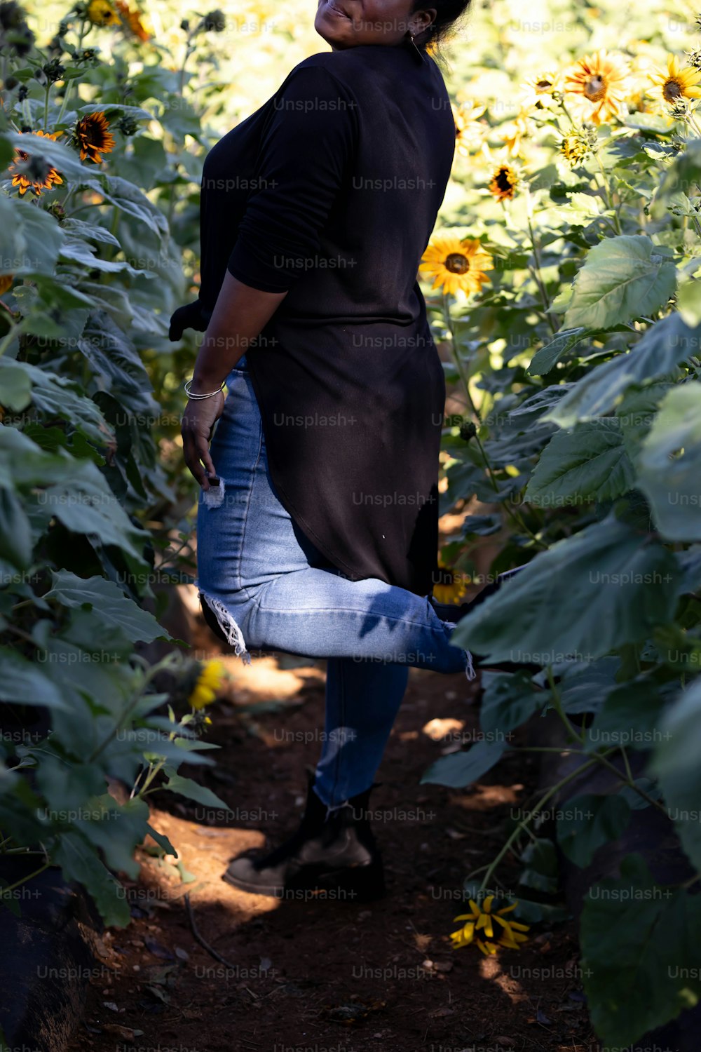 uma mulher em pé em um campo de girassóis
