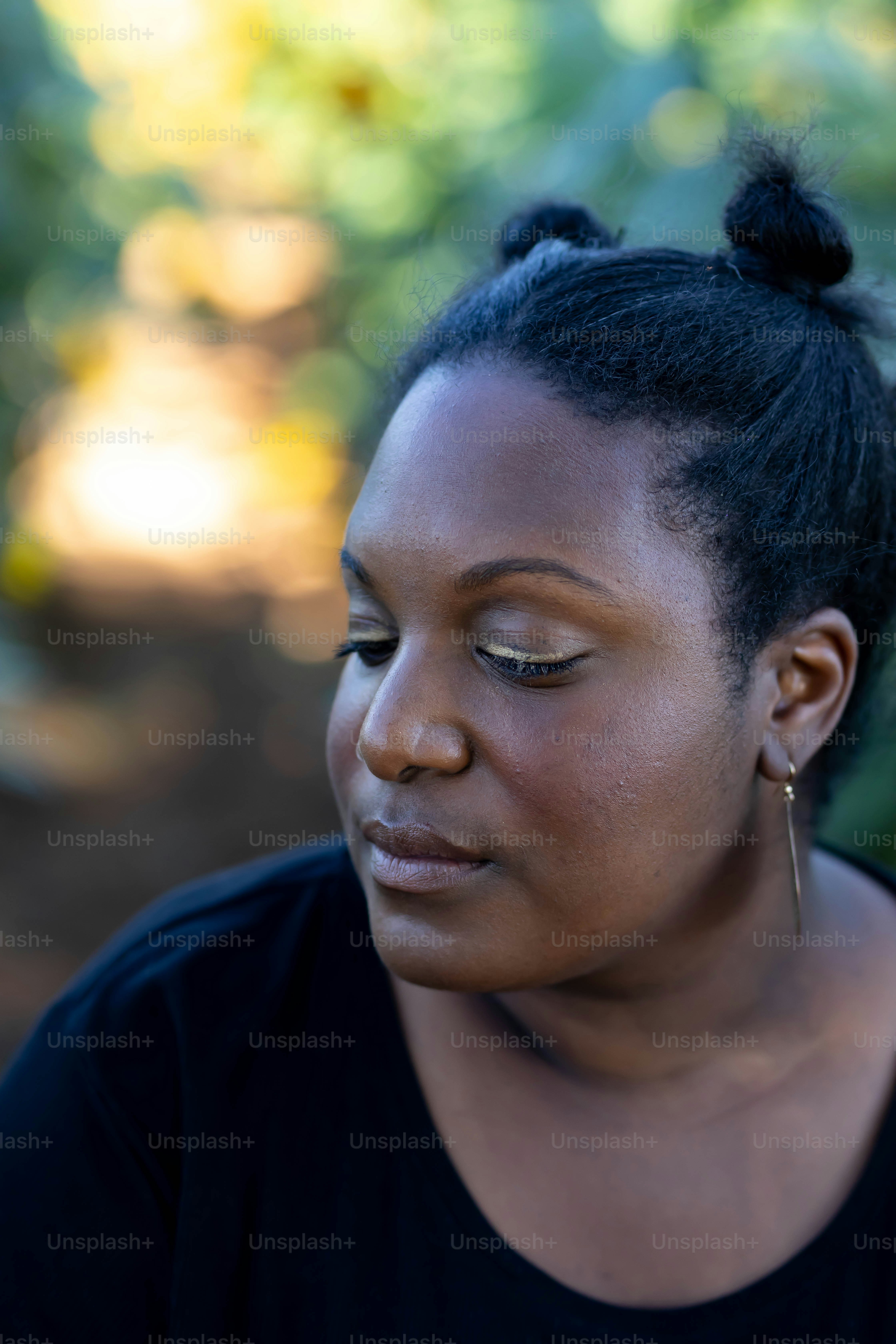 Une femme les yeux fermés regarde vers le bas
