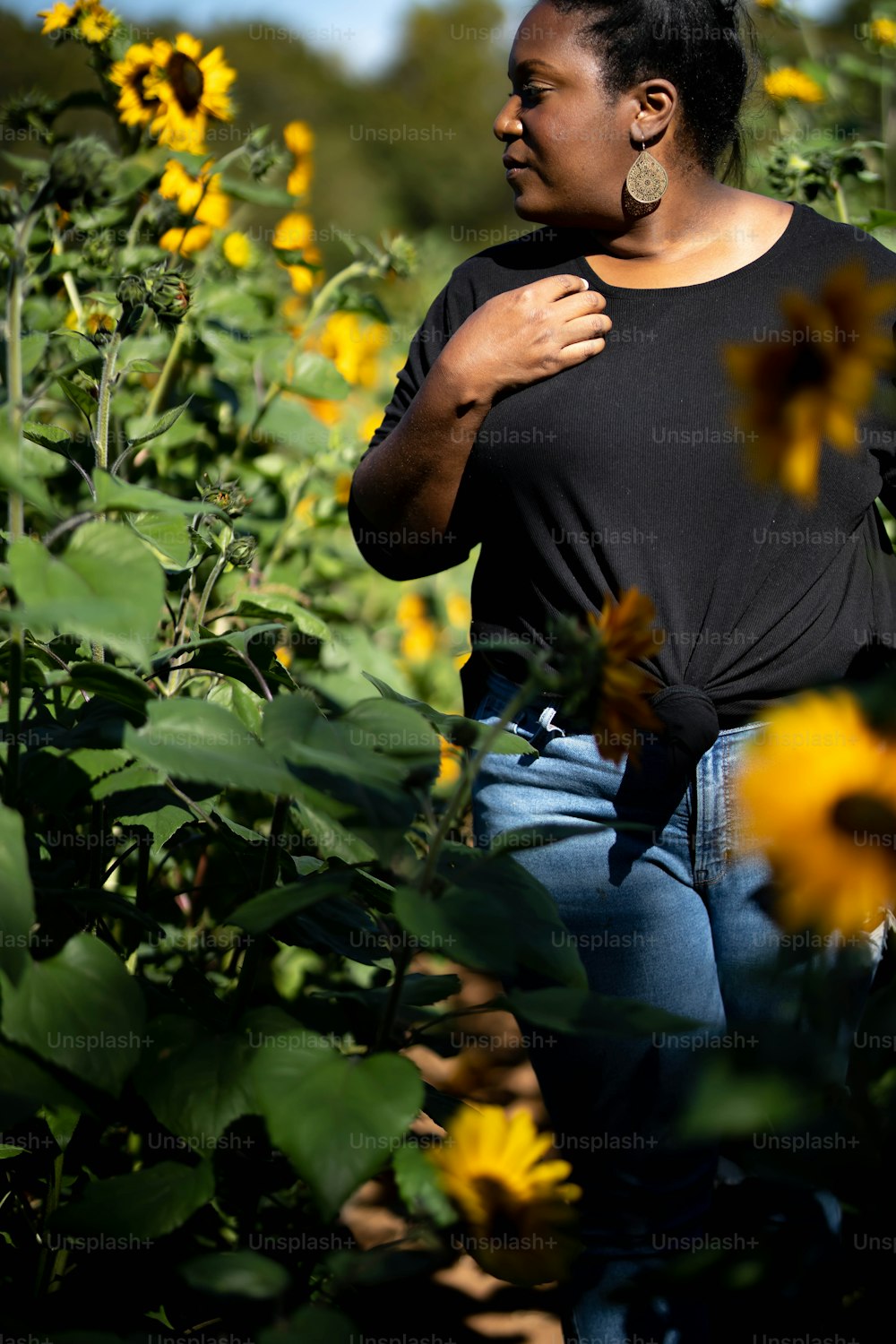 Eine Frau, die in einem Sonnenblumenfeld steht