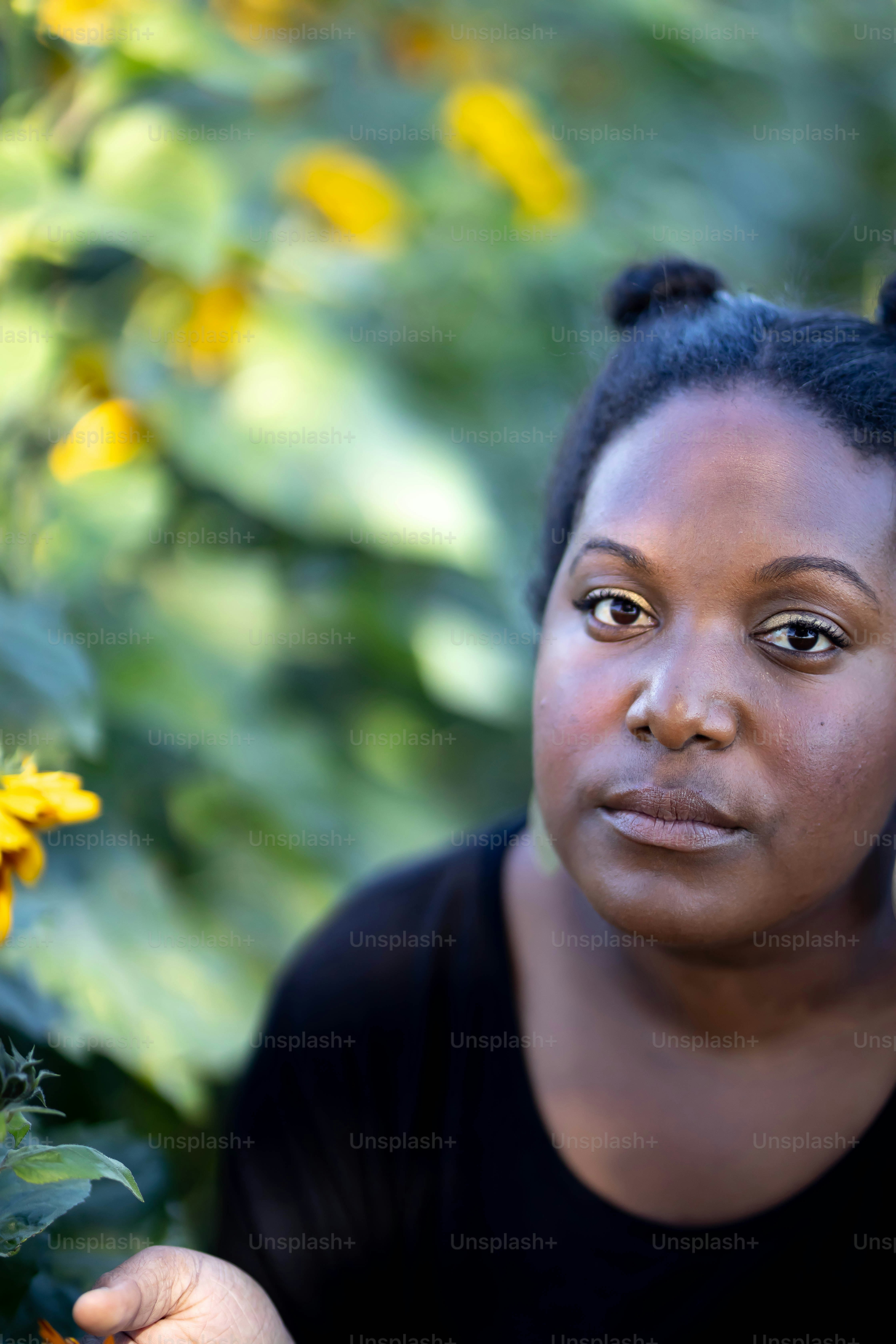 Une femme pose pour une photo devant des fleurs