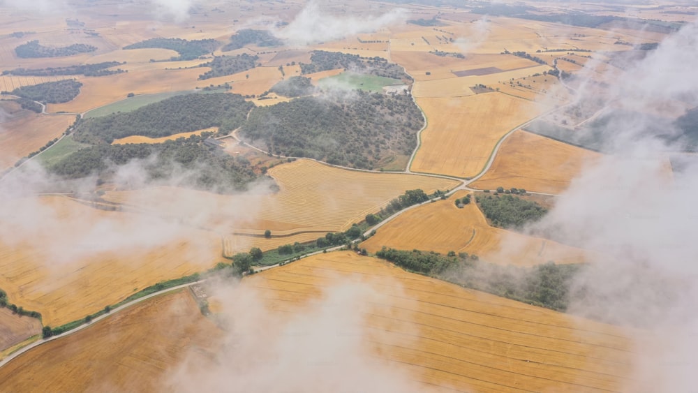 an aerial view of a field with clouds