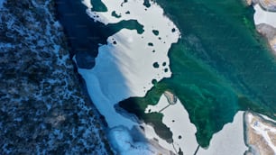 an aerial view of a lake surrounded by snow